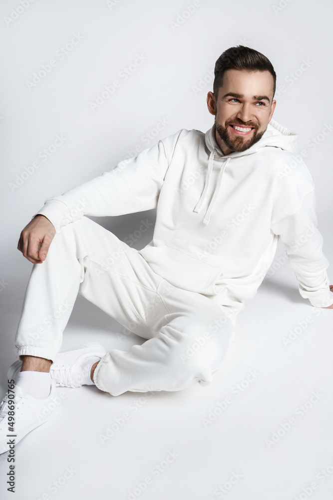 Wall mural Handsome smiling man wearing blank white hoodie and pants - Wall murals
