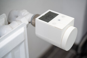 Modern smart heating valve with thermostat retrofitted to an old hot water heating system radiator...