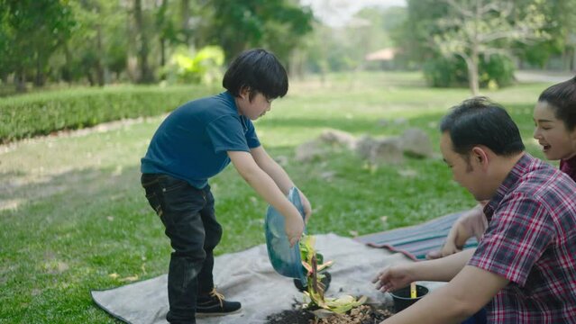 A family son is carry out scraps of fruits and vegetables to learn how to make natural compost. In the front garden on holidays