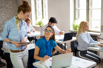 Fototapeta premium Portrait of business people having fun, working together and chatting at workplace office