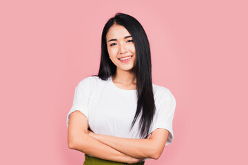 Asian happy portrait beautiful cute young woman standing her smile confidence with crossed arms isolated, studio shot on pink background and copy space, Thai female looking to camera