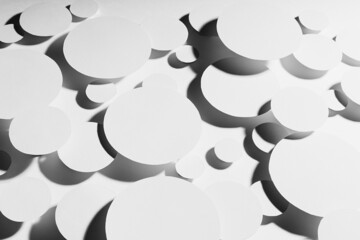 Modern energy motion swarm pattern of white paper ovals different size in hard light with contrast black strict shadows, top view. Contemporary activity abstract background.