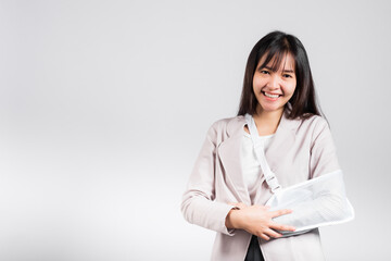 Arm broken. Business woman confident smiling broken arm after accident and wear arm splint for...