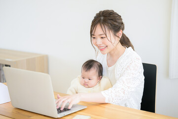 赤ちゃんと一緒に在宅ワークをするお母さん