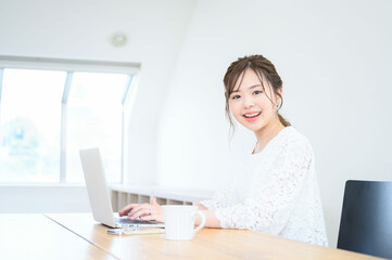 Woman working on computer at home, looking at camera