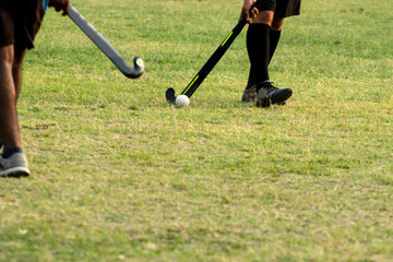 Boys are playing hockey. Hockey going to hit hockey ball.