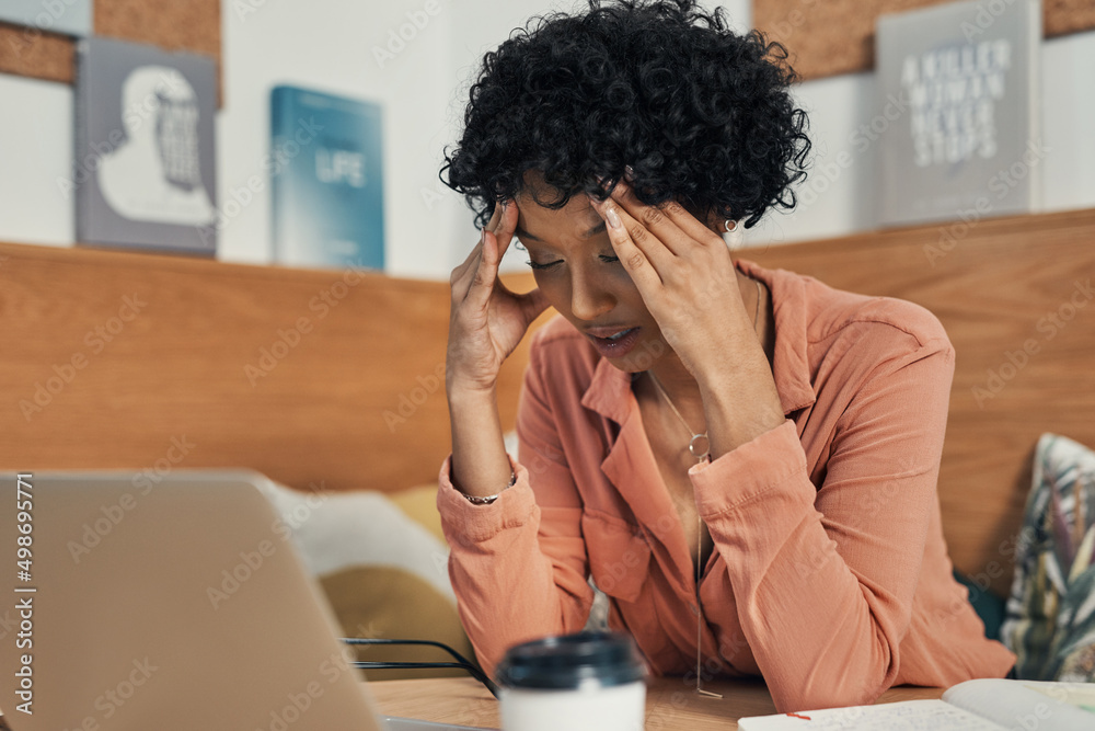 Poster im dealing with crisis after crisis. shot of a woman looking stressed while working from a cafe.