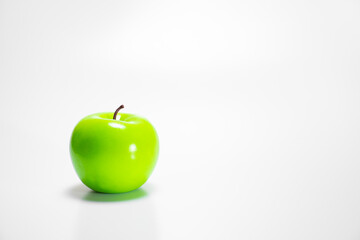 One single green apple with raindrops on a wooden background with a place for text: rustic food, harvest gardening, ingredients for a healthy snack, soft focus