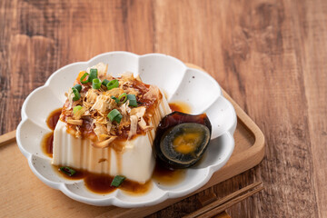 Delicious Chilled tofu and century egg with soy sauce and bonito flakes.