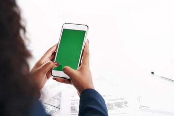 Getting big results from a small device. Cropped shot of an unrecognizable businesswoman using a smartphone with a green screen in a modern office.