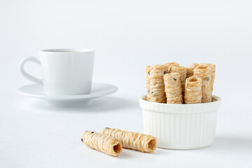 Vegetarian coconut milk dessert, a cup of espresso. Thai dessert - crispy coconut rolls on a white background.