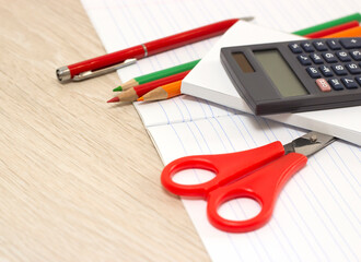 office supplies lie on a white notebook on a wooden table