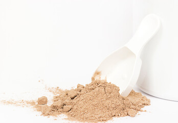 spoon with a bunch of brown powder on a white background