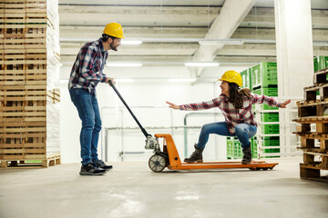 Workers playing with forklift and having fun at workplace.