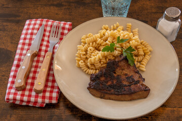 slice of cooked liver with pasta on a plate