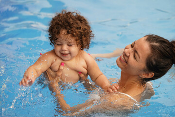 Mother and baby having fun in a swimming pool