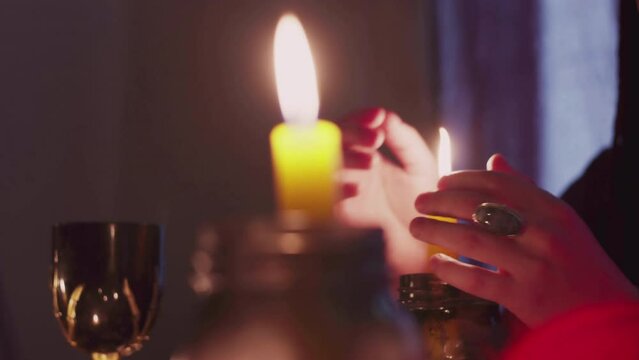 Side view of male fortune teller moving hands above the magic candle