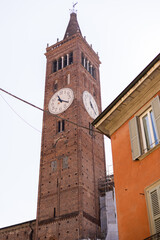 Fototapeta na wymiar a brick tall old clock tower in italy city