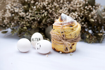 Fototapeta na wymiar Easter cake on a white background and next to three eggs with pictures