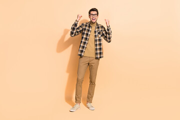 Fototapeta premium Full length body size view of attractive cheerful lucky guy rejoicing having fun isolated over beige pastel color background