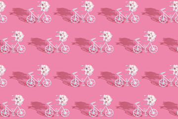 Patternn with decorative bicycles with flowers on pink background