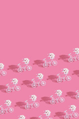 Patternn with decorative bicycles with flowers on pink background. Vertical format with copy space