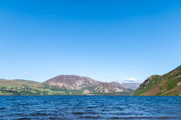 Wast Water or Wastwater is a lake located in Wasdale, a valley in the western part of the Lake District National Park, England, UK, beautiful summer day and blue cloudy sky