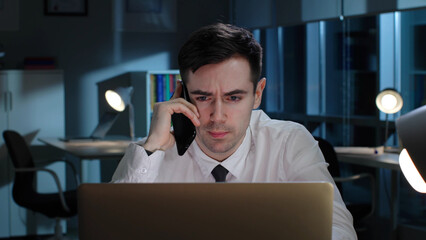 Close up of salesman have phone call and use laptop working late at night