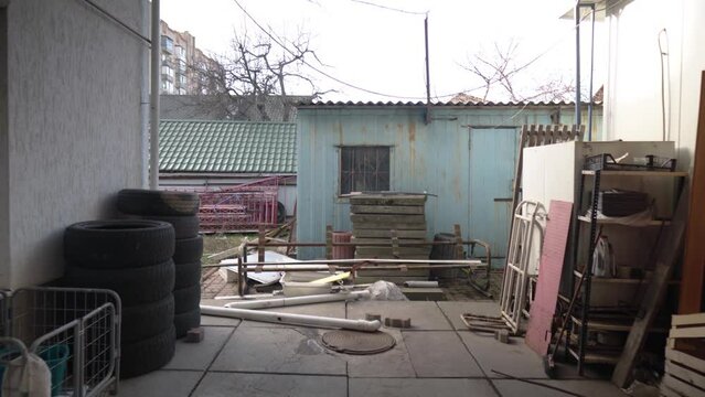 Abandoned yard behind the old house. Lots of old things are everywhere. Smoth camera move.