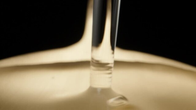 I pour water on a golden spoon, a drop of water. Dolly slider extreme close-up. Laowa Probe