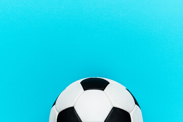 Fototapeta na wymiar Top view photo of white and black soccer ball as football concept . Minimalist flat lay image of leather football ball over blue turquoise background with copy space.