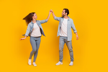 Naklejka premium Full length body size view of attractive cheery funny people dancing pastime isolated over bright yellow color background