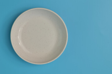 White plate isolated on a blue background