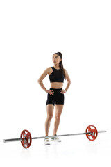 Fototapeta na wymiar Full length portrait of muscled woman in sportswear exercising with a weight, barbell isolated on white background. Sport, weightlifting concept