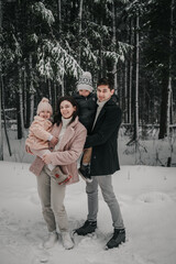 A married couple with two children in a snowy forest