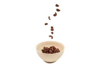 Chocolate corn flakes falling to the white bowl isolated on white. Motion.