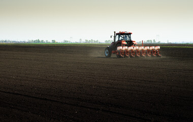 Fototapeta premium Tractor and seeder for sowing corn