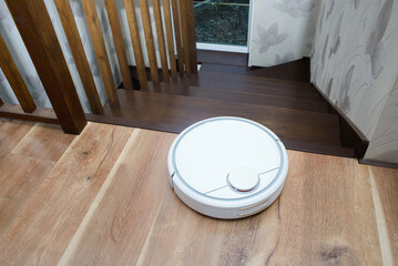 Robot vacuum cleaner on laminate wood floor, Smart robotic automate wireless cleaning technology...