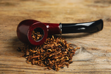 Smoking pipe with tobacco on wooden table
