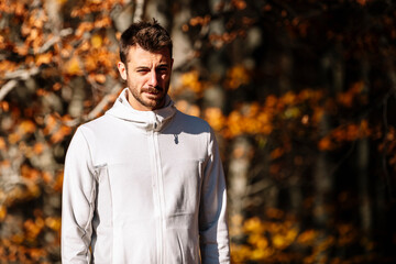 Young man running at park during autumn morning