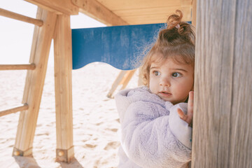 Little girl enjoying a winter sunny day at the beach playground
