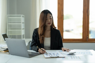 business woman working on desk office with a calculator to calculate the numbers, finance accounting concept