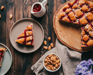 Cherry pie on wooden table with almonds