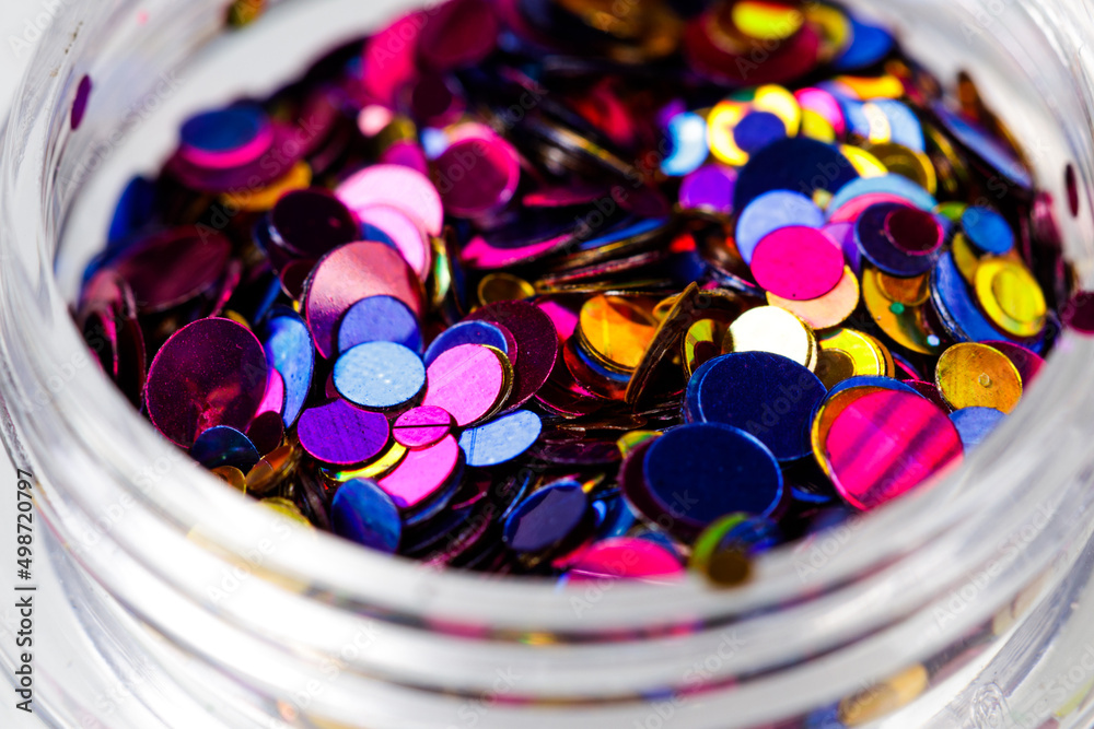 Poster colored sequins in a plastic jar close-up