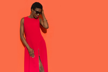 Beautiful black woman in red long dress and sunglasses.