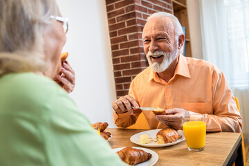 Senior couple eating breakfast at home.