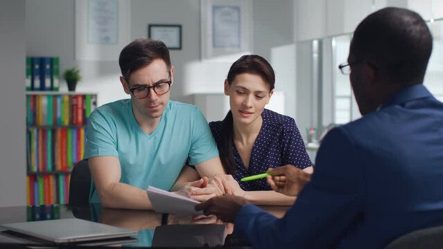 Young couple read loan contract meeting with bank manager
