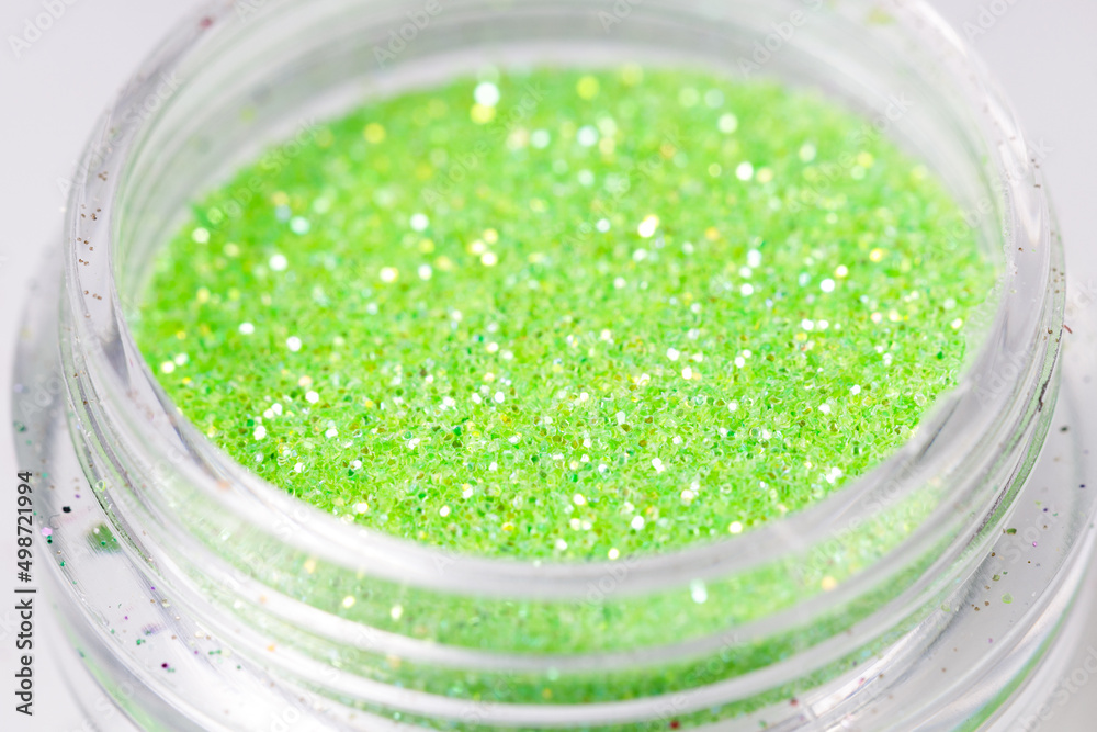 Poster colored sequins in a plastic jar close-up