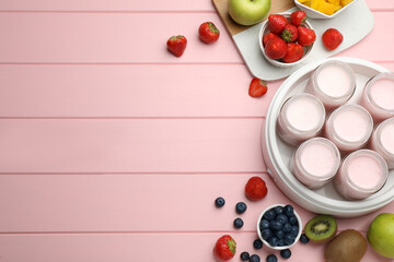 Naklejka na ściany i meble Modern yogurt maker with full jars and different fruits on pink wooden table, flat lay. Space for text