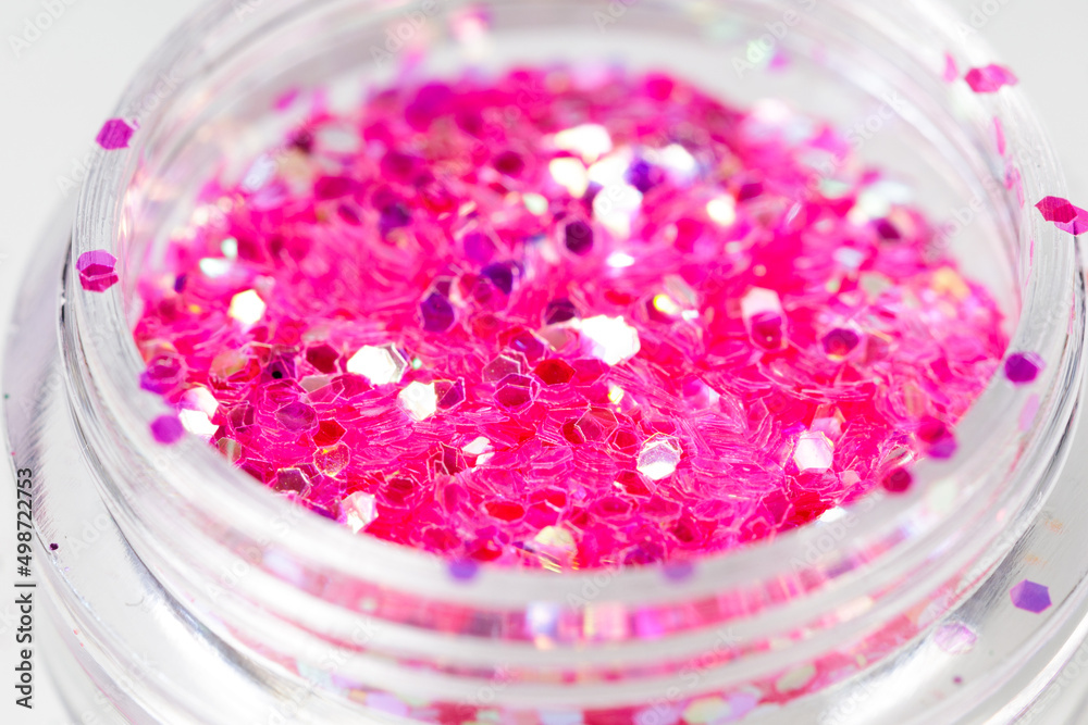 Poster colored sequins in a plastic jar close-up